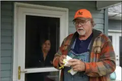  ?? The Associated Press ?? ACT OF KINDNESS: In this April 24 file photo, Dennis Ruhnke holds two of his remaining N-95 masks as he stands with his wife, Sharon at their home near Troy, Kan. Dennis, a retired farmer, shipped one of the couple’s five masks left over from his farming days to New York Gov. Andrew Cuomo for use by a doctor or a nurse.