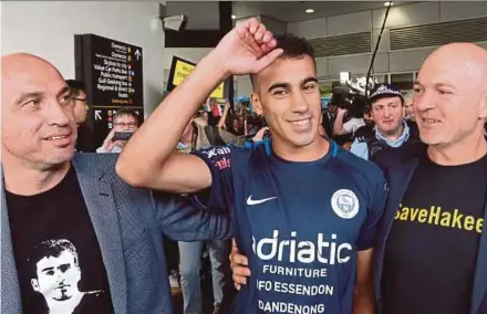  ?? REUTERS PIC ?? Supporters greeting refugee footballer Hakeem Al-Araibi (centre) as he arrives at Melbourne Internatio­nal Airport in Melbourne yesterday.