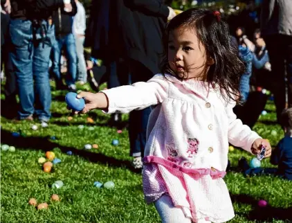  ?? Sophia Germer/The Chronicle 2015 ?? Sophia Feng helps collect eggs at the annual Easter egg hunt in San Francisco’s Duboce Park.