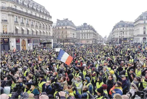  ??  ?? Protesters wearing yellow vests demonstrat­e on the Place de l’opera in Paris on Saturday against rising costs of living they blame on high taxes. — AFP