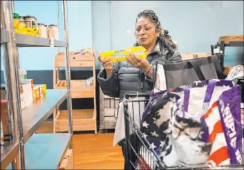  ?? Seth Wenig
The Associated Press ?? Betsy Quiroa shops at a market-style food pantry on Nov. 15 at the Carver Center in Port Chester, N.Y. A number of states are working to keep food out of landfills.