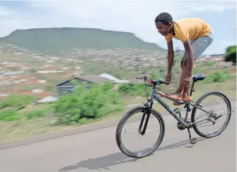  ?? | KHAYA NGWENYA ?? THIRTEEN-YEAR-OLD Ziyanda Nzimande manoeuvres downhill on his bicycle in Kwaximba, Cato Ridge, where former regent chief Zibuse Mlaba was gunned down a few days ago. African News Agency (ANA)