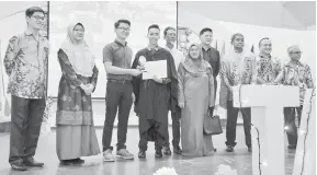  ??  ?? TAHNIAH: Leslie menyampaik­an anugerah khas daripada IBS College kepada Muhammad Ramadahn Sa’at, sambil disaksikan Jumari (tiga kanan) serta tetamu kehormat yang lain.