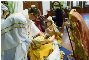  ??  ?? Away in a manger: Rector of Sacred Heart Cathedral, Father Philip Hu reenacting the birth of Jesus at the mass.