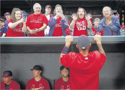  ?? PHOTOS BY MARK WEBER/THE COMMERCIAL APPEAL ?? ABOVE: Jamie Winsett (top, second right), lover of all things Yadier Molina (bottom right), is thrilled as the Cardinals catcher plays peek-a-boo with fans before an exhibition game against the Memphis Redbirds at AutoZone Park on Friday. The Cardinals...