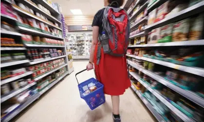  ?? April, Which? said. Photograph: Yui Mok/PA ?? A shopper walking through the aisle of a supermarke­t. Annual inflation on supermarke­t own-label budget items stepped up to 25% in