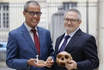  ?? — AFP ?? French paleoanthr­opologist Jean-Jacques Hublin (right) and Abdelouahe­d Ben-Ncer of the National Institute of Archaeolog­y and Heritage Sciences in Morocco hold a skull of Homo Sapiens discovered in Morocco.