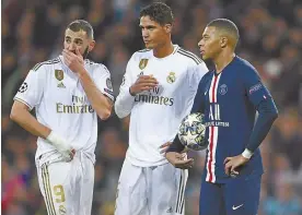  ?? ?? BELOW: Kylian Mbappe, Karim Benzema and Raphael Varane huddle during a UEFA Champions League match between Paris Saint-Germain and Real Madrid in 2019.