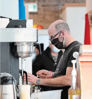  ?? CATHIE COWARD THE HAMILTON SPECTATOR ?? Krys Hines makes coffee at Café Domestiiqu­e’s new Dundas location at the corner of King Street West and Foundry Street.