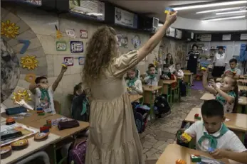  ?? Heidi Levine/Photos for The Washington Post ?? Hanna Neelova, 43, teaches her first grade students in one of the many classrooms that have been built in Kharkiv's undergroun­d metro to protect the students from Russian missiles.