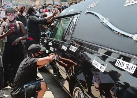  ?? DANA JENSEN/THE DAY ?? People tape names of those who have died onto a hearse at Parade Plaza during the “We’re Fed Up! Black Lives Matter Protest” on Saturday in New London. Visit www.theday.com for a video from the protest.