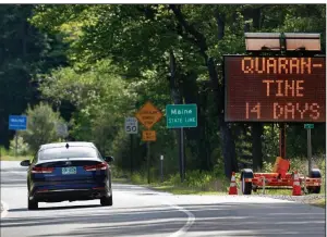  ?? (AP/Robert F. Bukaty) ?? A sign in Gilead, Maine, near the border with New Hampshire, warns visitors entering Maine that they are required to quarantine for 14 days.