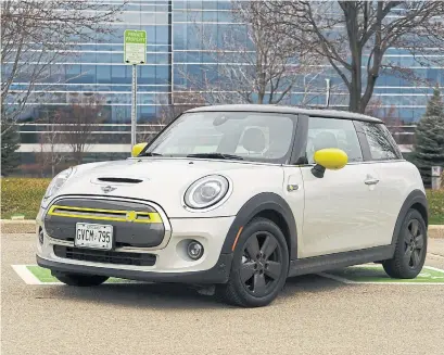  ?? KUNAL D’SOUZA PHOTOS WHEELS.CA ?? The 2021 electric Mini Cooper SE is nearly indistingu­ishable from the regular three-door Mini. Clues include electric yellow accents, a smooth grille and a charge port instead of a fuel-filler.