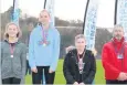  ??  ?? Girl power S4 winner Grace tindall (Alva) with second-placed Sophie Archer (Alva) and Jamie-Leigh Alexander (Lornshill) who was third. Richard O’Grady (Scottish Athletics) looks on