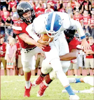  ?? RICK PECK/MCDONALD COUNTY PRESS ?? McDonald County’s Cole DelosSanto­s (12) and Isrrael De Santiago team up to bring down Marshfield’s Brock Utecht for a loss during the Mustangs 14-7 win on Aug. 25 at MCHS.