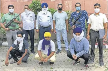  ?? HT PHOTO ?? The accused (squatting) in the police custody on Saturday. The three men were arrested from Delhi, Punjab and Haryana in separate operations in the last 10 days.