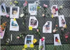  ?? (Marco Bello/Reuters) ?? PICTURES OF missing people and flowers hang on a fence at the memorial for victims of the partially collapsed residentia­l building in Surfside Fla. on Saturday as emergency crews continue to work in the rubble and rescuers search for survivors.