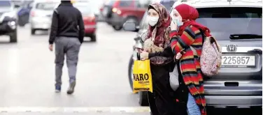  ?? Agence France-presse ?? ↑
Women, wearing protective masks, stand in the vicinity of the Rafik Hariri University Hospital in Beirut on Saturday.