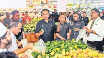  ??  ?? Khairul Anwar (fourth right) together with Econsave head Mas Imran Adam (right) checking the prices of goods after the launching. — Bernama photo