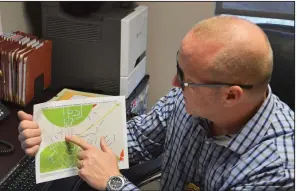  ?? (Arkansas Democrat-Gazette/Stephen Simpson) ?? Mike Cooke, the sex offender manager for the North Little Rock Police Department, points at a map that he sometimes gives registrant­s who are looking for places live.