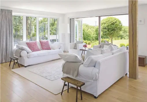  ??  ?? Living area
The galleried landing allows light to flow through from the first floor (far left), while furniture and fabrics in white and neutral shades create a feeling of calm. Sofas, Sofa Workshop. Stools,
Acorn Antique Interiors. Cushions,
Tori...