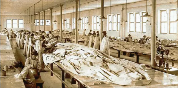  ?? Foto: Sammlung Häußler ?? Augsburg um 1910: An langen Tischen nähen und kleben Frauen in einer Halle der Ballonfabr­ik Riedinger Ballon‰ und Luftschiff­hüllen.