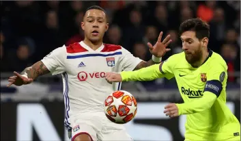  ??  ?? Lyon forward Memphis Depay (left) challenges Barcelona forward Lionel Messi, right, during the Champions League round of 16 first leg soccer match between Lyon and FC Barcelona in Decines, near Lyon, central France, on Tuesday.AP Photo/LAurent CIPrIAnI