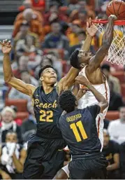  ?? Michael Thomas / Associated Press ?? Texas guard Kendal Yancy tries to complete a dunk against Long Beach State’s LaRond Williams, left, and Jordan Griffin during the first half Saturday.