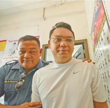  ?? SUNSTAR / AMPER CAMPAÑA ?? BONIEL. Bohol Provinciia­l Board Member Rey Boniel (right) is escorted by a police officer after signing an affidavit related to the charges filed against him.