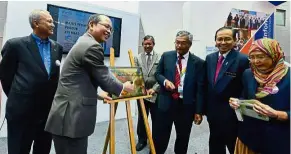  ??  ?? Innovative summit: Tangau launching MCY 2016 Products, Deep Wound Management by Sirim (M) Berhad and Big Data Solution by Speedminer Sdn Bhd. With him is Mosti sec-gen Datuk Seri Dr Mohd Azhar Yahaya (second from right).