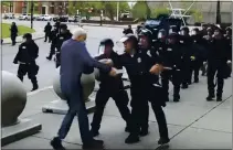  ?? WBFO ?? A Buffalo police officer shoves a 75-year-old protester who walked up to police June 4 in Buffalo, N.Y. Video from a local TV station shows the man appearing to hit his head on the pavement.