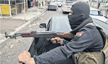  ??  ?? Members of the Iraqi National Security Service drive through eastern Mosul on their way to arrest a suspected Isil collaborat­or