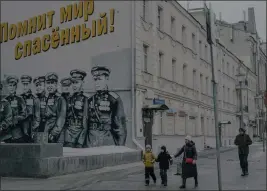  ?? NANNA HEITMANN — THE NEW YORK TIMES ?? Pedestrian­s walk past a patriotic mural dedicated to victory in World War II in Moscow on Friday. President Vladimir Putin's invasion has met setback after setback in Ukraine, but its effect at home has been very different.