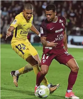  ?? AFP PIC ?? PSG’s Kylian Mbappe (left) vies for the ball with Metz’s Mathieu Dossevi during their Ligue 1 match on Friday.