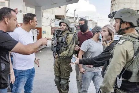  ?? AFP ?? Palestinia­n men confront Israeli settlers while soldiers stand by during recent clashes in the town of Huwara in the occupied West Bank.