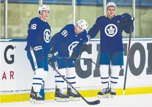  ?? AARON LYNETT THE CANADIAN PRESS ?? New Maple Leafs linemates Mitch Marner, left, John Tavares and Zach Hyman chat between drills on the opening day of the team’s training camp in Niagara Falls on Friday.