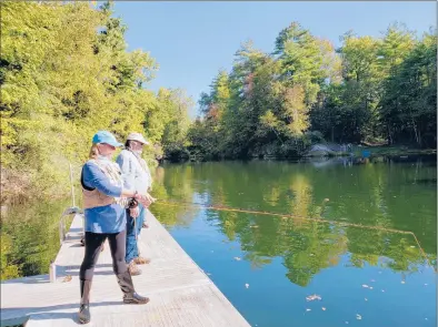  ?? LORETTA WALDMAN | SPECIAL TO THE COURANT ?? Lisa Parrett of Bridgeport, a participan­t in the Connecticu­t Casting for Recovery retreat in September, tries her hand at fly fishing while fishing guide Butch Buchta looks on. Fourteen women taking part in this year’s Connecticu­t retreat spent the morning at Limestone Trout Club in Caanan, learning the basics of fly fishing with the help of club members who volunteere­d as guides.