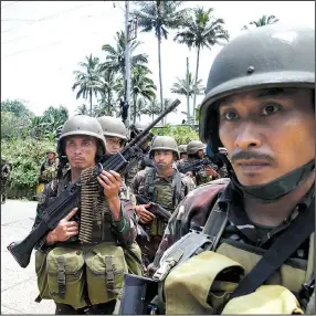  ?? AP/ BULLIT MARQUEZ ?? Philippine troops prepare Tuesday to move against Islamic militants holed up in the southern city of Marawi with 200 captives, including a Catholic priest, after a week of fi ghting that began with a failed raid to capture militant commander Isnilon...