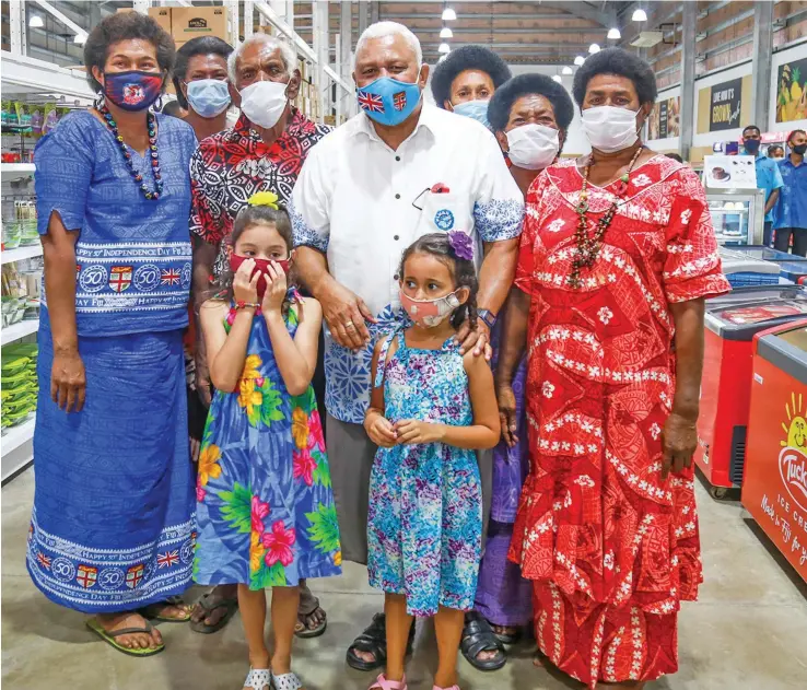  ?? Photo: Leon Lord ?? Prime Minister Voreqe Bainimaram­a (middle) with Sabeto villagers during the newly opened Grace Road True Mart store in Sabeto Nadi on 14 October 2021.