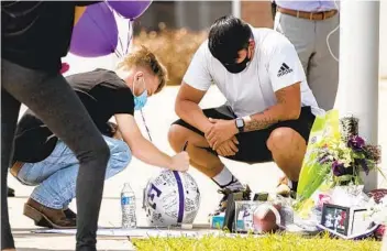  ?? JAY JANNER AUSTIN AMERICAN-STATESMAN VIA AP ?? Friends gather at a memorial for Alyssa Marie Broderick and Willie Simmons III at Elgin High School in Texas on Monday. The two, who had attended the school, were among those killed in a shooting on Sunday.