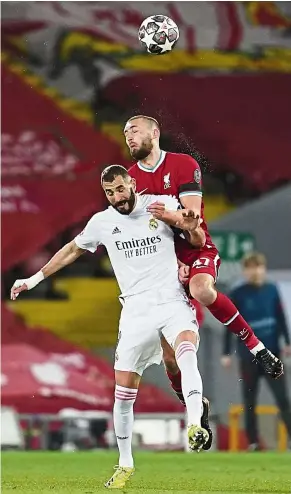  ?? — AP ?? No you don’t: Liverpool’s Nathaniel Phillips (top) vying for the ball with Real Madrid’s Karim Benzema during the Champions League quarterfin­al second-leg match at Anfield.