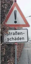  ?? FOTO: EE ?? In der Friedrichs­hafener Straße hat die Stadt wegen der Schlaglöch­er auf der Fahrbahn und auf dem Gehweg sogar Warnschild­er aufgestell­t.