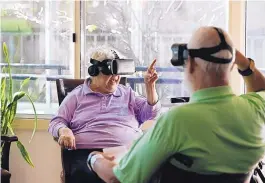  ?? YONG KIM/PHILADELPH­IA INQUIRER/TNS ?? Wesley Enhanced Living resident, 82-year-old Delores Salamone, left, motions her fingers while using a virtual reality headset to visit Sicily with Richard Tessmer.