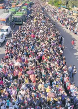  ?? PRAWESH LAMA/HT ?? Migrant workers wait to board buses at Anand Vihar in New Delhi on Saturday.