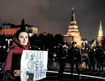  ?? Dimitar Dilkoff / AFP via Getty Images ?? A protester holds a sign reading “Enough Putin for me” in Moscow last week. A new Russian law that faces a nationwide vote next month could lead to President Vladimir Putin staying in office for 16 more years.
