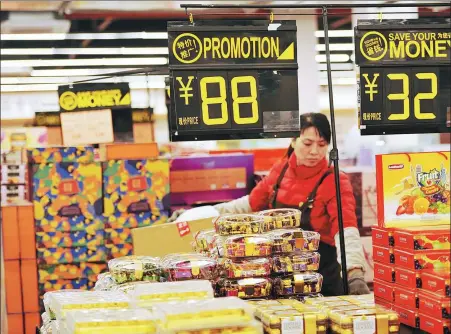  ?? YU FANGPING / XINHUA ?? A saleswoman arranges imported snacks at a duty-free store in Qingdao, Shandong province.