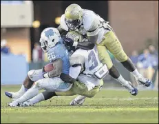  ?? ROBERT WILLETT / RALEIGH NEWS & OBSERVER ?? Georgia Tech’s Jabari Hunt-Days (32) and Izaan Cross stop North Carolina’s Giovani Bernard late in the fourth quarter.