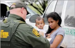  ?? AP PHOTO DAVID J. PHILLIP ?? A mother migrating from Honduras holds her one-year-old child as surrenderi­ng to U.S. Border Patrol agents after illegally crossing the border Monda near McAllen, Texas.