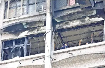  ?? — Reuters photo ?? Fire inspectors view damage after a fire broke out at the Taipei Hospital.