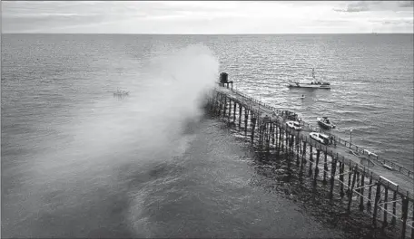  ?? OCEANSIDE PIER Sandy Huffaker AFP/Getty Images ?? burns on Thursday. The emergency response saved 90% of the landmark wooden structure, a city spokespers­on said.